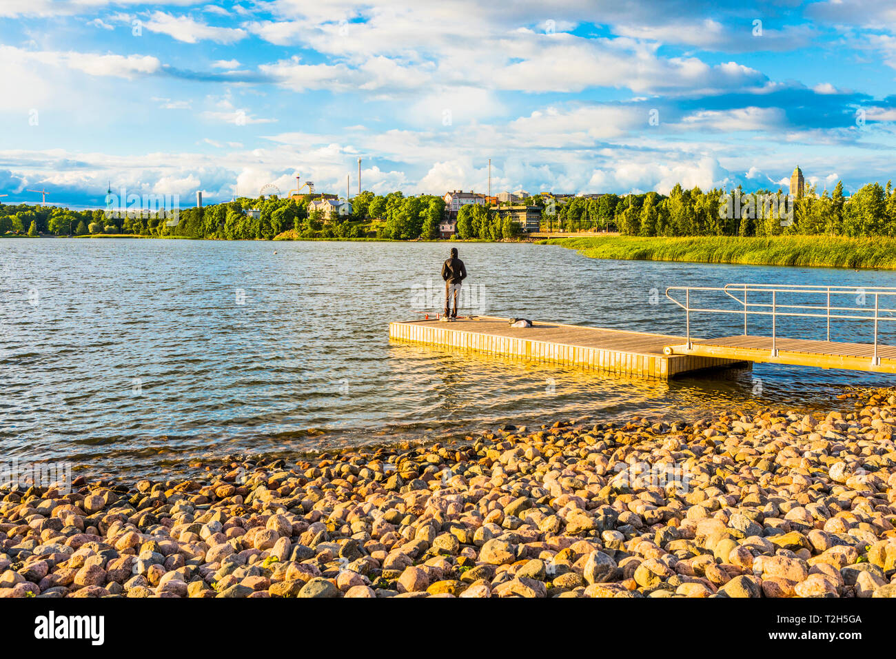 Uomo di pesca sul molo nel Toolo Bay, Helsinki, Finlandia, Europa Foto Stock