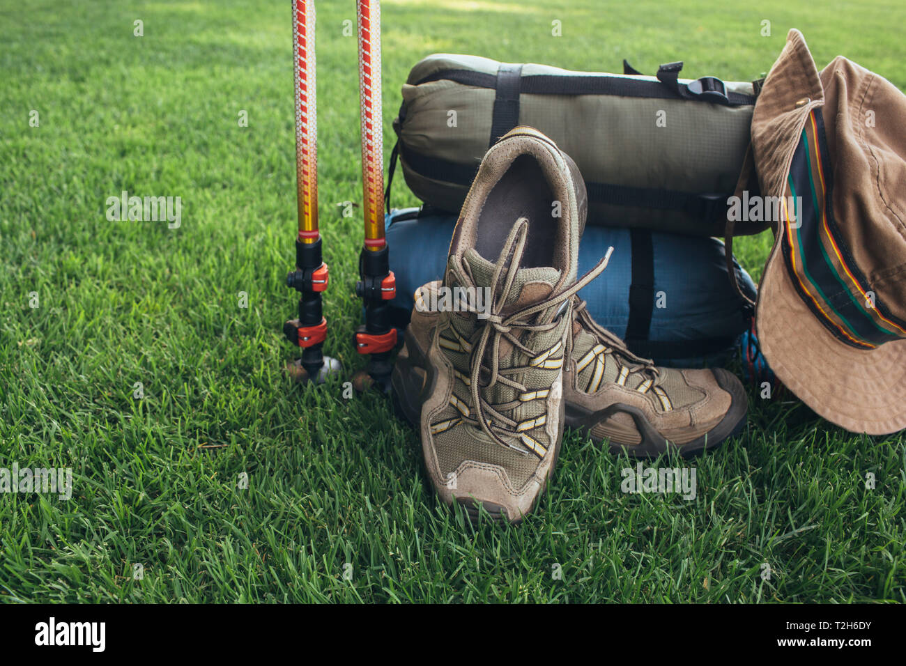 Pali trekking, stivali, , il sacco a pelo , hat e altre apparecchiature backpacker, sull'erba verde close-up Foto Stock
