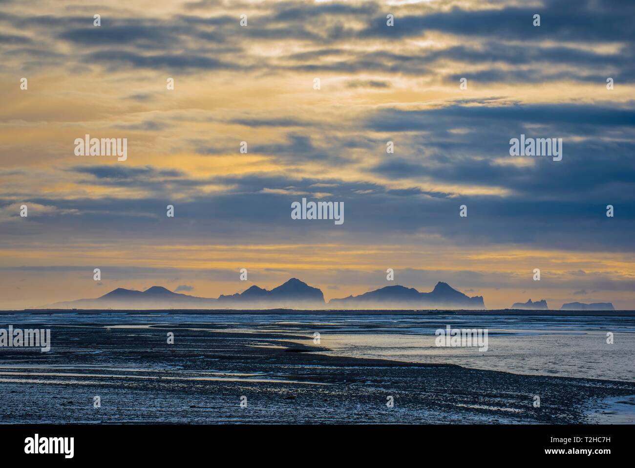 Vista dalla terraferma alle isole Westman con cielo nuvoloso, Vestmannaeyjar, Sudurland, Islanda Foto Stock