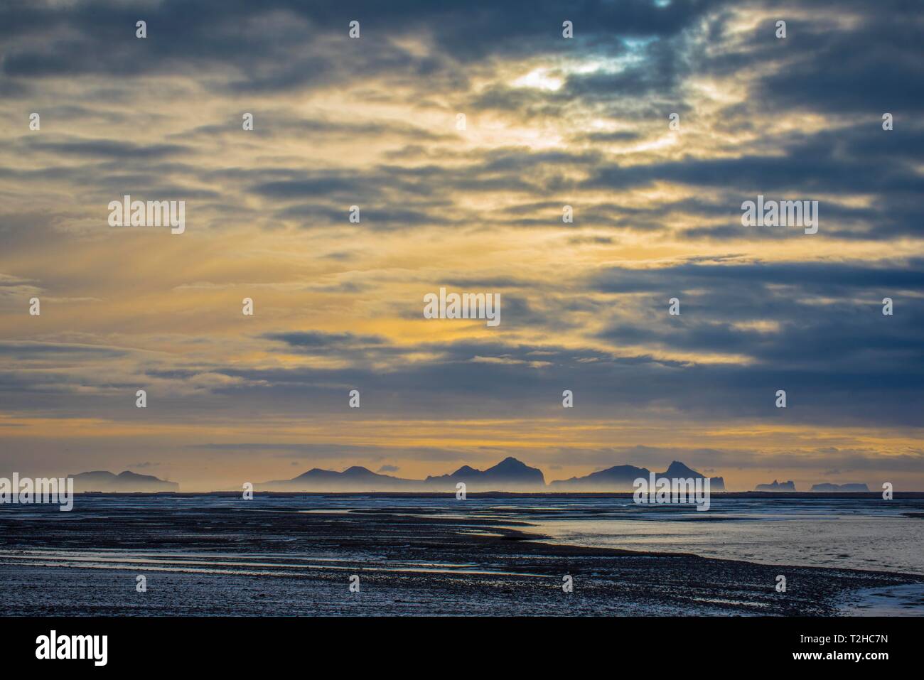 Vista dalla terraferma alle isole Westman con cielo nuvoloso, Vestmannaeyjar, Sudurland, Islanda Foto Stock