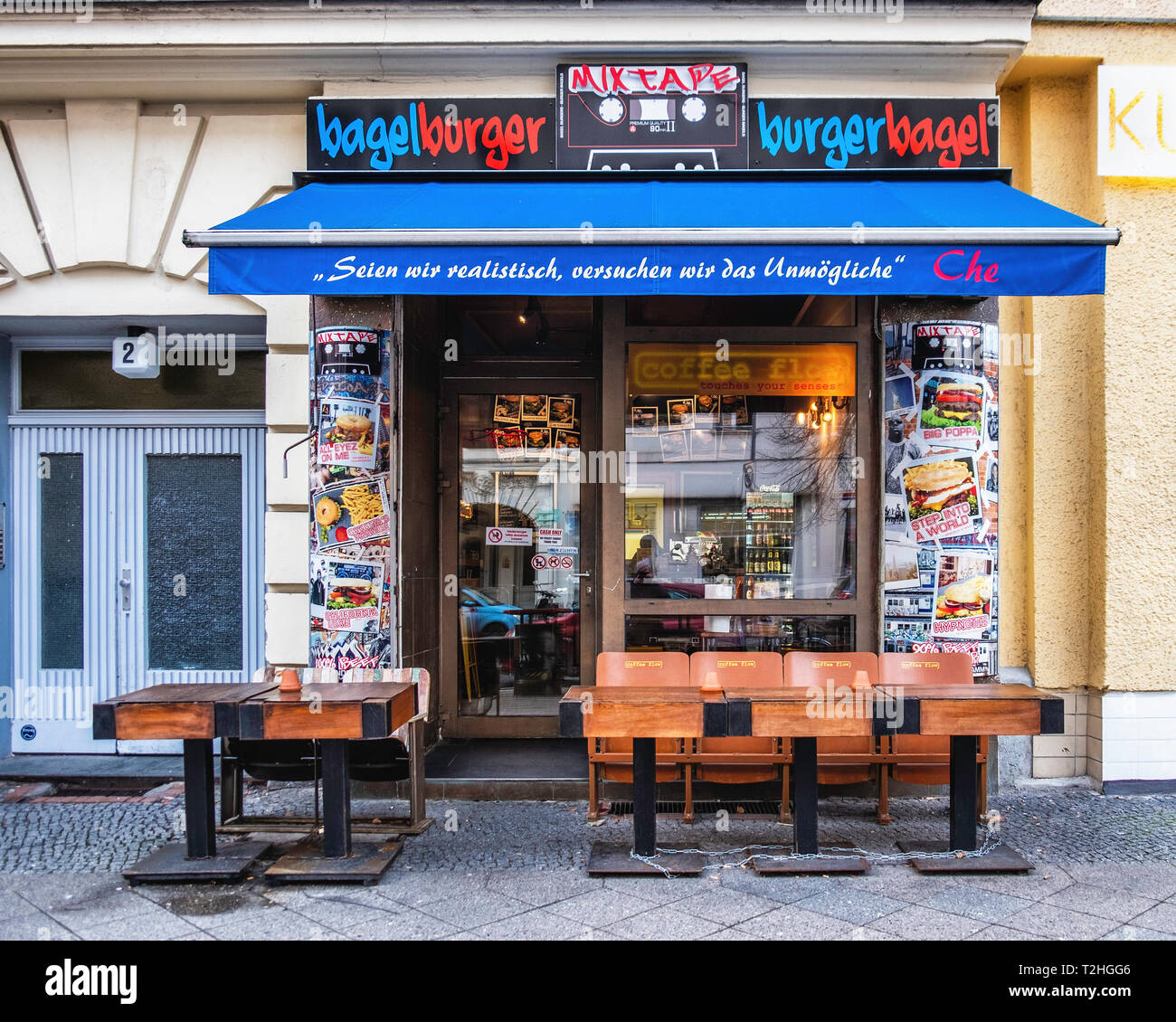 Berlin Alt-Moabit. BurgerBagel fast food. Colori degli esterni con vecchi tavoli in legno su un marciapiede Foto Stock