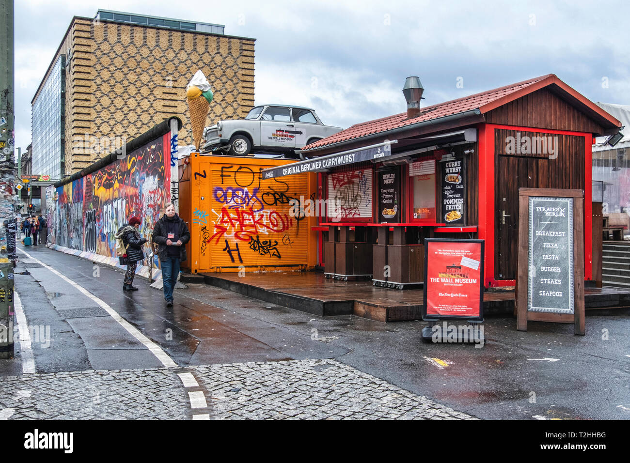 Berlino,Friedrichshain. Muro di Berlino East Side Gallery. Segmento di parete, chiosco Currywurst & vecchia Trabant vettura Foto Stock
