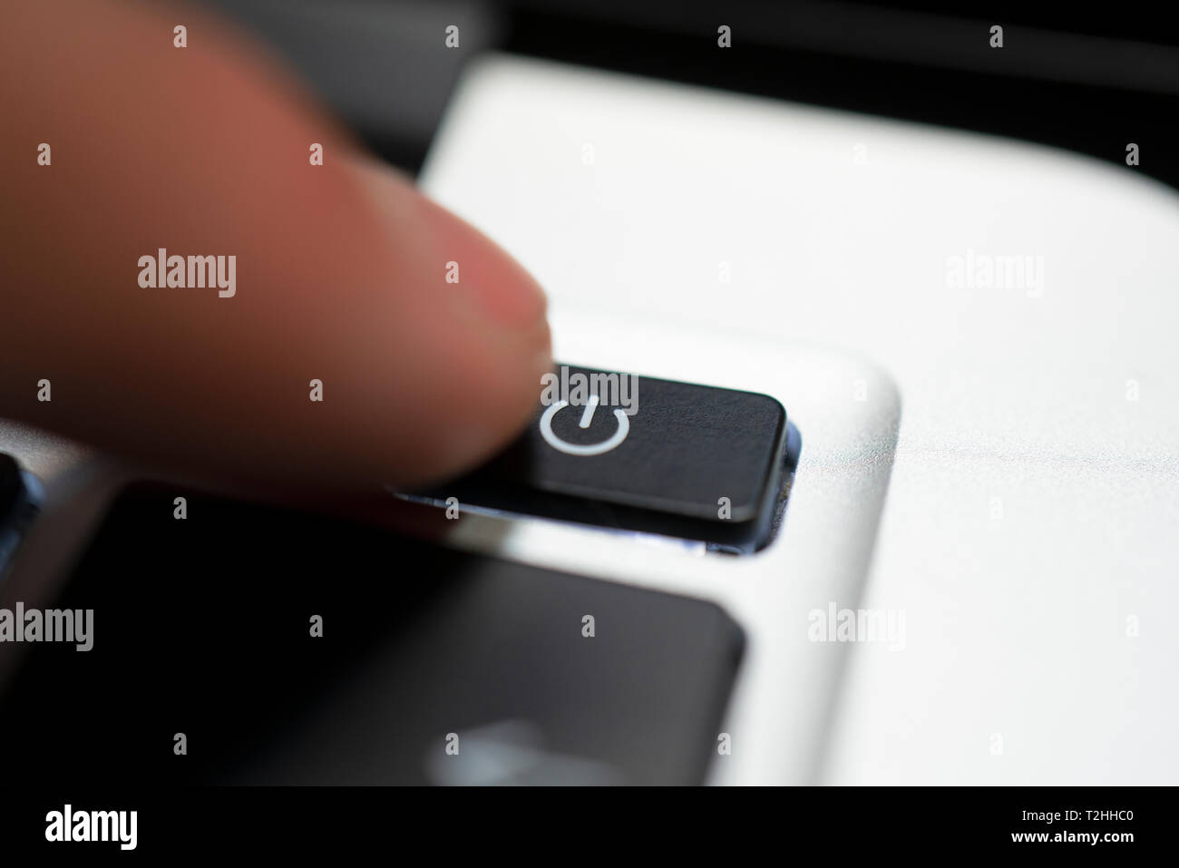Mano umana premere il pulsante di spegnimento sulla tastiera del computer Foto Stock