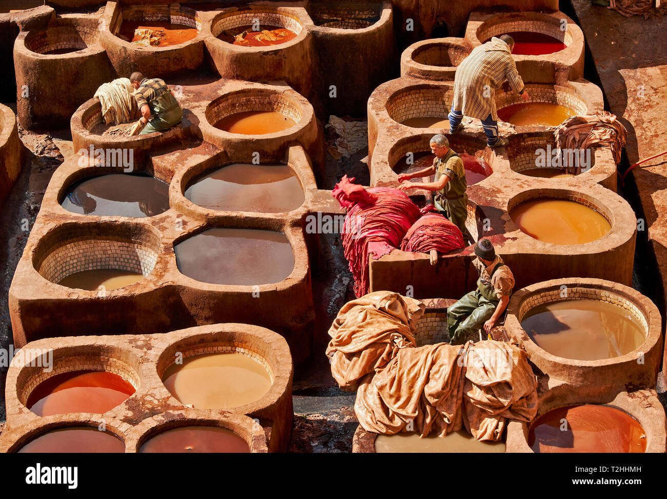 Il Marocco Fes Medina La conceria CHOUARA nasconde in vasche con pigmenti colorati e quattro lavoratori ordinamento della pelle Foto Stock