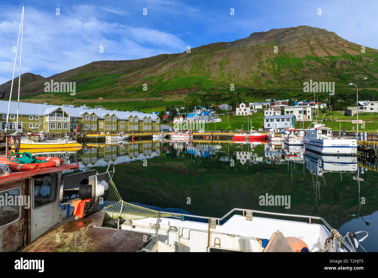 Porto, hotel e barche da pesca, montagne, riflessioni, Siglufjörður Affitto, (Siglufjorour), splendida estate meteo, Nord Islanda, Europa Foto Stock