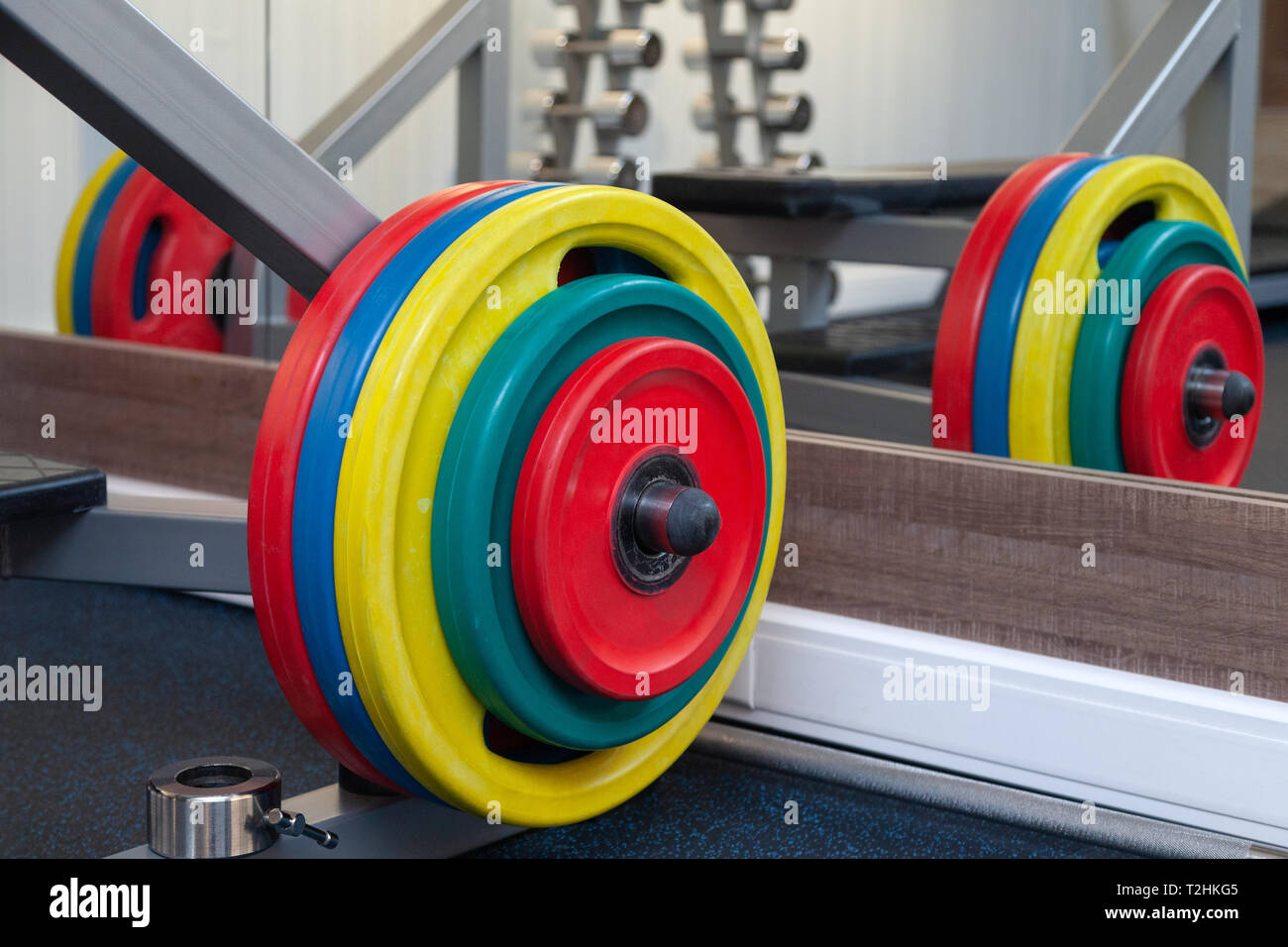 Closeup obright multicolore di manubri, barbells, pesi su supporto nella moderna palestra dell'hotel. Il concetto di uno stile di vita sano, perdita di peso, formazione bo Foto Stock