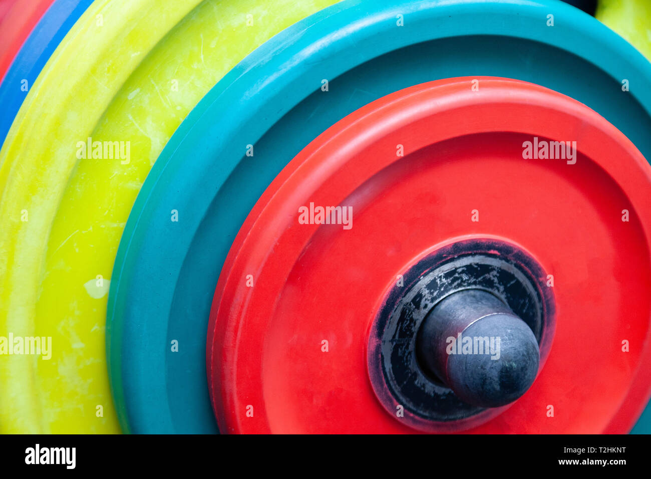 Closeup obright multicolore di manubri, barbells, pesi su supporto nella moderna palestra dell'hotel. Il concetto di uno stile di vita sano, perdita di peso, formazione bo Foto Stock