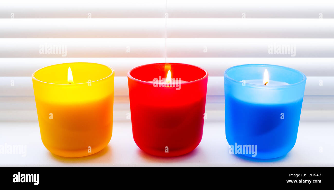 Luminose colorate candele. Profumate candele colorate con stoppini  illuminato Foto stock - Alamy