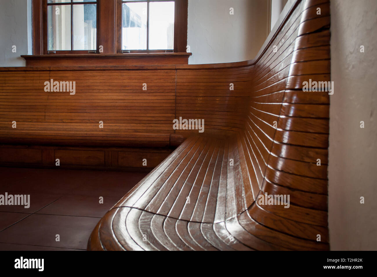 Lucido legno curvo stazione ferroviaria panchina Foto Stock