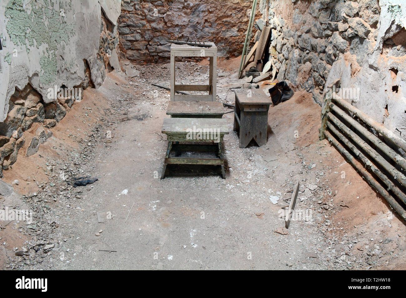 Stato orientale penitenziario - Legno sgabello in abbandonato cella di prigione Foto Stock