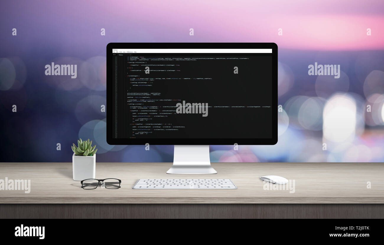 Concetto di programmazione su un computer. Scrivania con computer display e editor di testo. Foto Stock