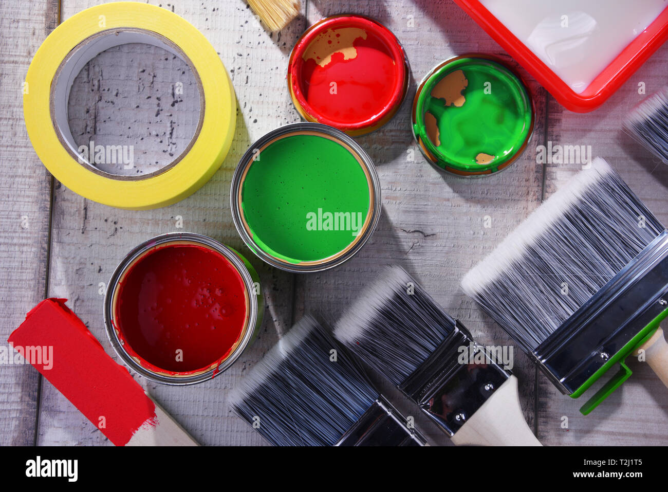 Barattolo di vernice e pennelli di diverse dimensioni per la decorazione della casa fini. Foto Stock