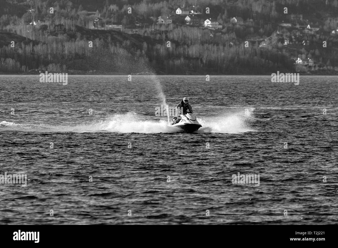 Una persona che guida un idrogetto (o getto d'acqua) in Byfjorden, un fiordo aperto al di fuori del porto di Bergen, Norvegia. Mese di Marzo, ancora basse temperature ... Foto Stock