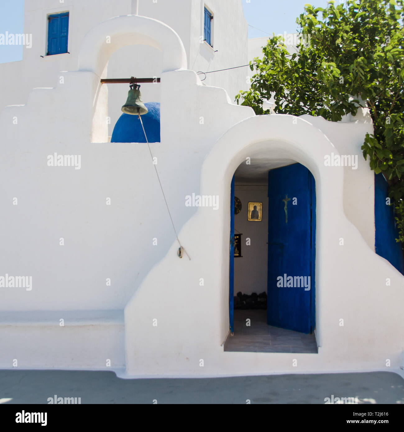 Una porta blu luminosa si apre su una piccola chiesa greco-ortodossa sull'isola di Santorini, in Grecia. Foto Stock