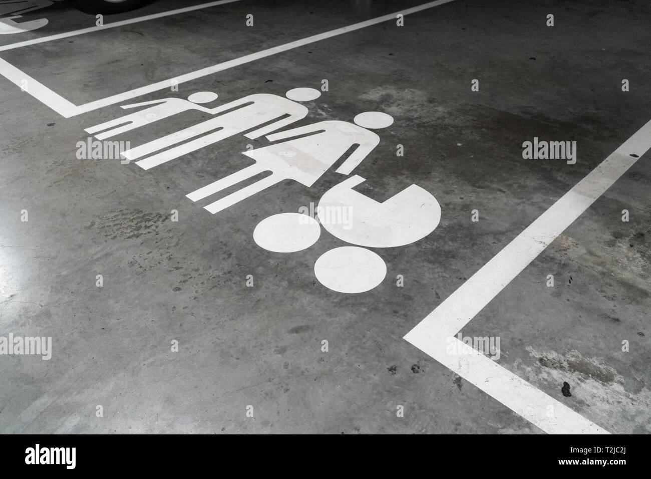 Parcheggio con la famiglia icona dipinta sul pavimento in calcestruzzo Foto Stock