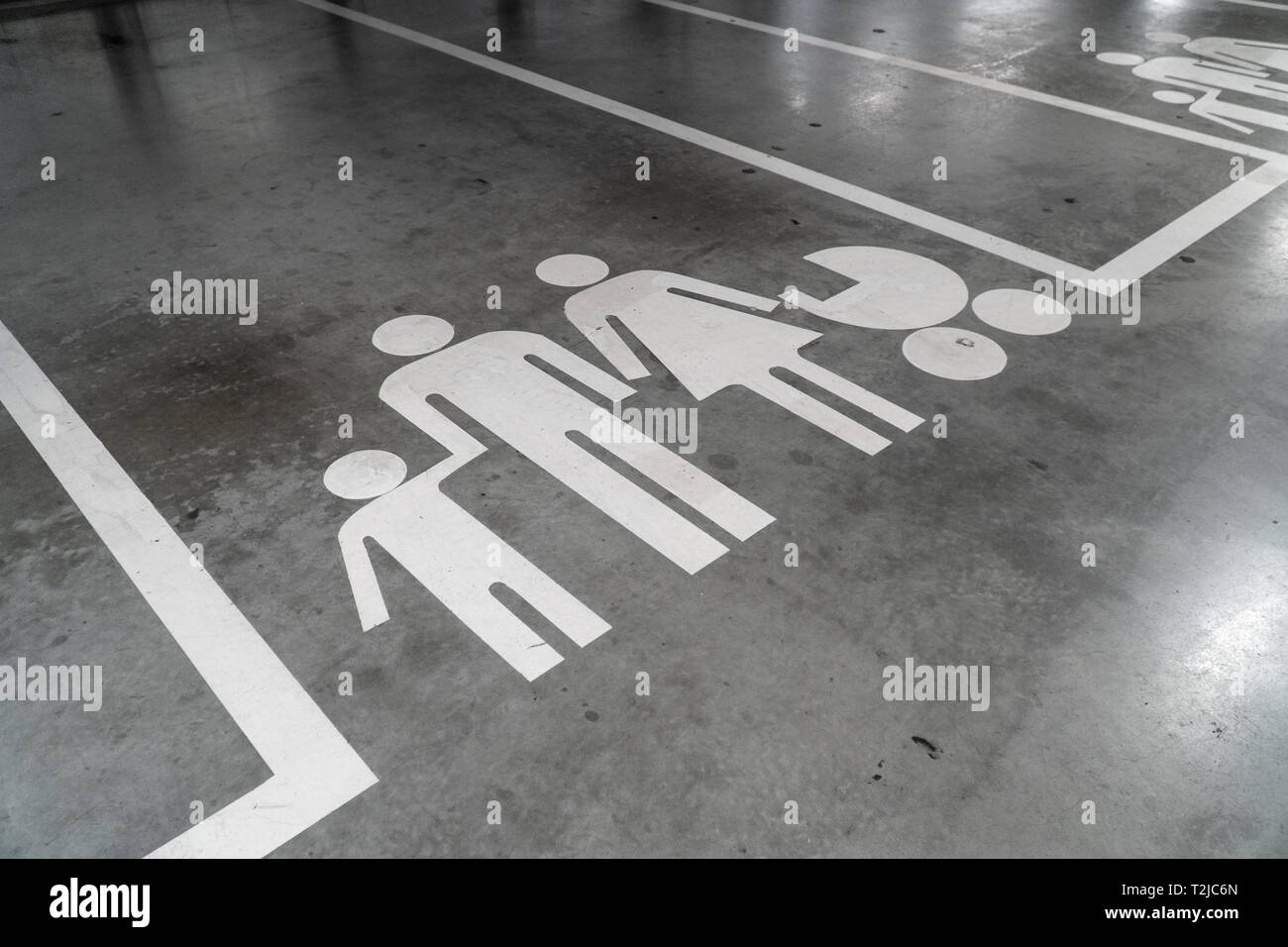 Parcheggio con la famiglia icona dipinta sul pavimento in calcestruzzo Foto Stock