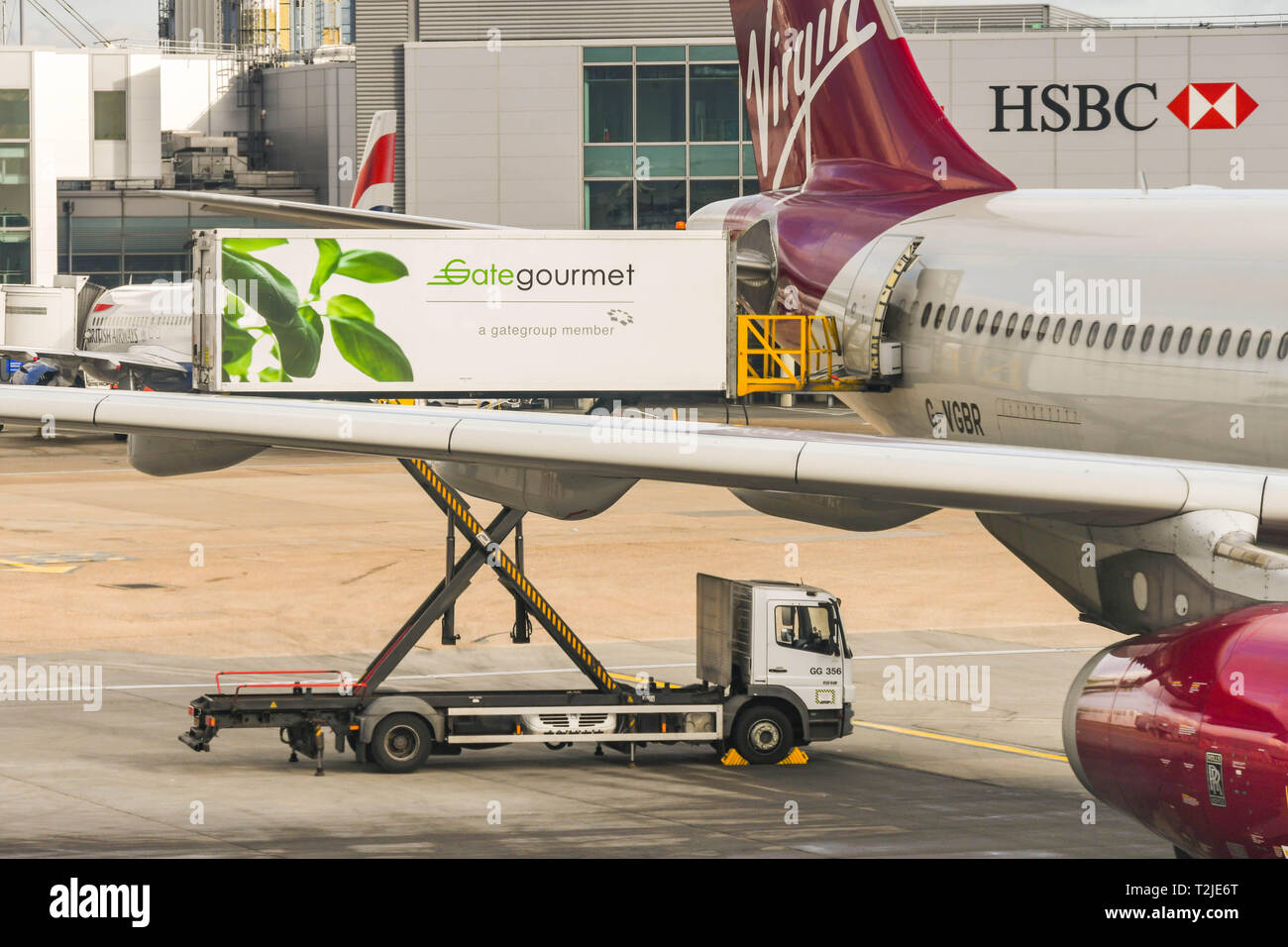 Dall'Aeroporto Heathrow di Londra, Inghilterra - Febbraio 2019: un Gate Gourmet elevatore a pantografo del carico del veicolo catering attraverso lo sportello posteriore di un Virgin Atlantic jet Foto Stock