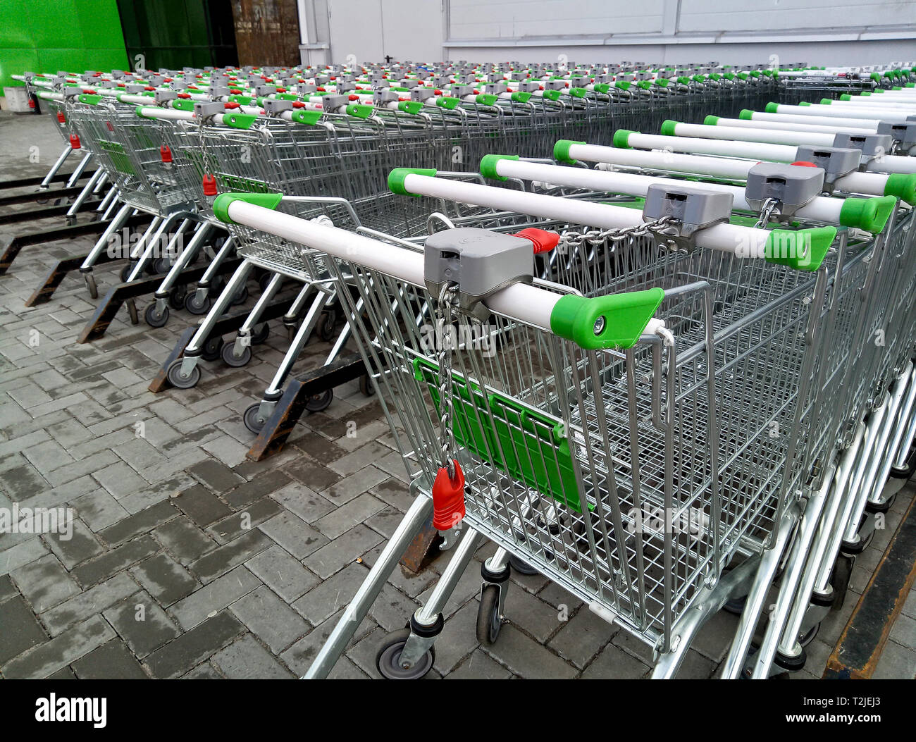 Righe di pronto per l'uso carrelli di shopping allineate in righe per lo stoccaggio vicino a un supermercato o hyper market Foto Stock