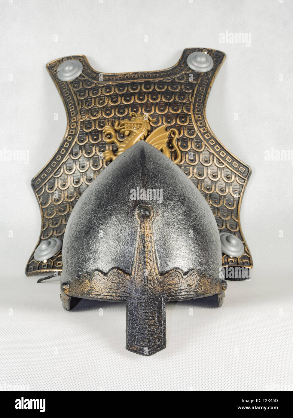 Un casco medievale con un naso di scudo e di un pettorale decorato con l'immagine di un drago. Toy medievale, cavaliere del equipaggiamento. Foto Stock