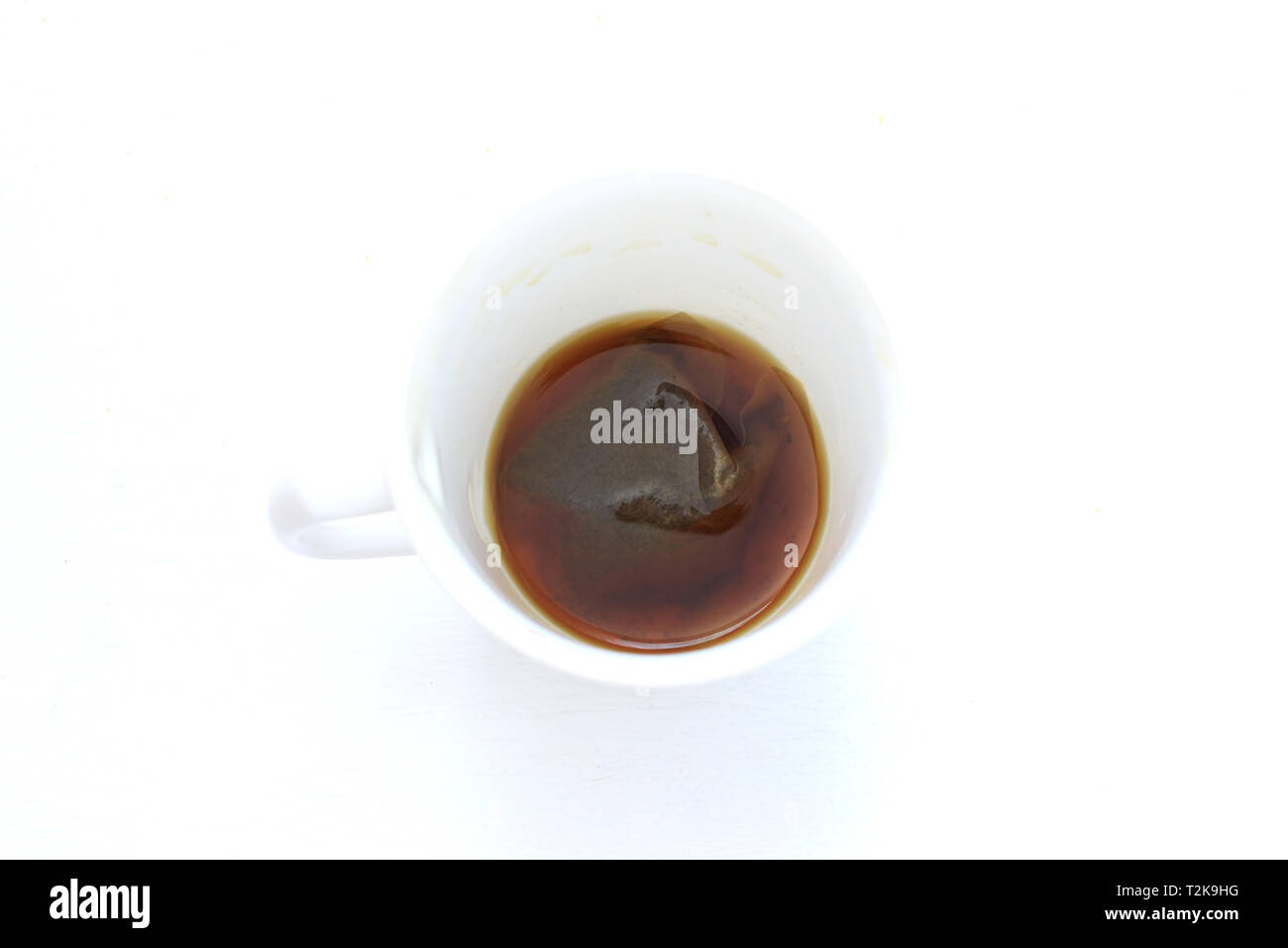 Bere tè in tazza bianca isolata contro uno sfondo bianco Foto Stock