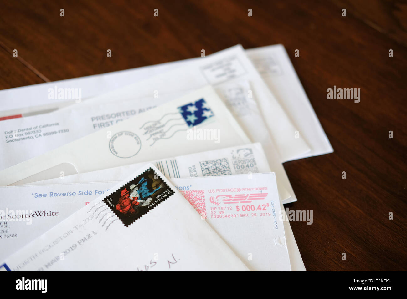 Un assortimento di buste e lettere con annullato Servizio Postale degli Stati Uniti spedizione su di un tavolo di legno alto. Foto Stock
