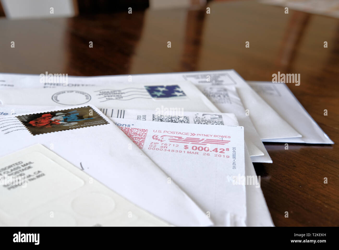 Un assortimento di buste e lettere con annullato Servizio Postale degli Stati Uniti spedizione su di un tavolo di legno alto. Foto Stock