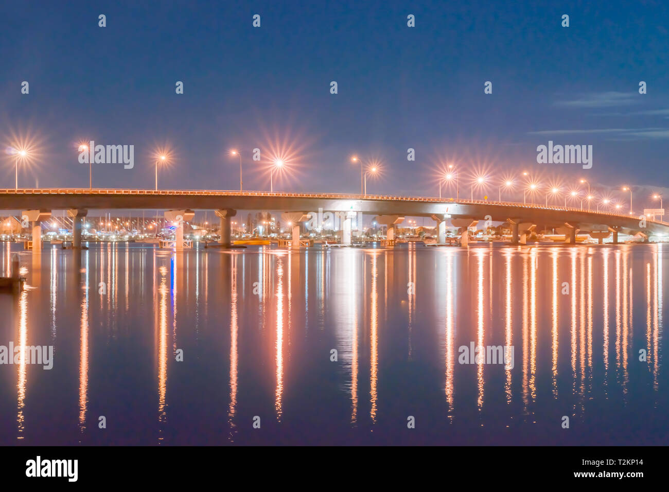 Tauranga Harbour Bridge strett illuminata sopra le luci e le luci della città al di sotto di notte Foto Stock