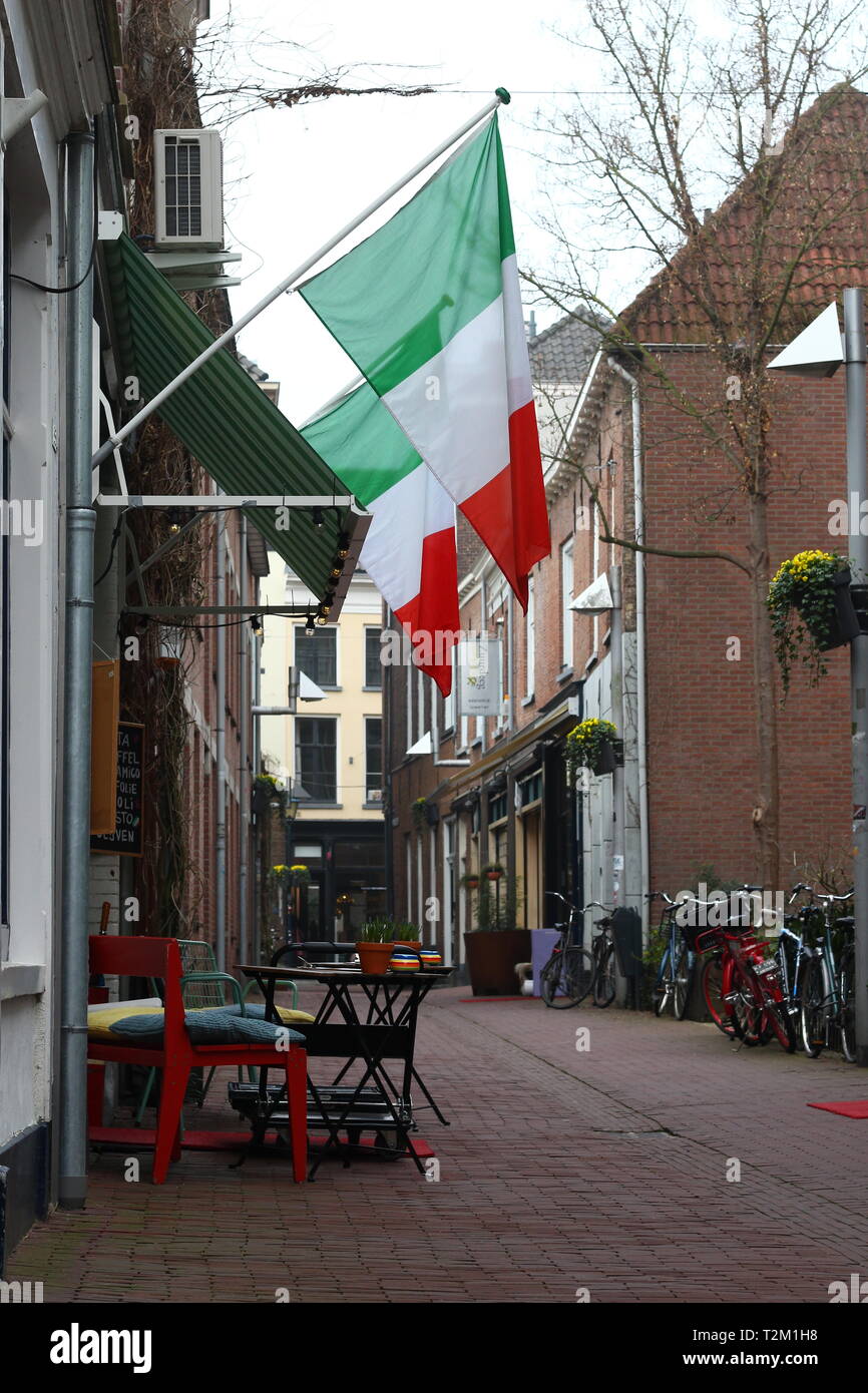 ARNHEM, Paesi Bassi - 22 Marzo 2019: Antica strada nel centro di Arnhem con bandiere italiane, terrazza e biciclette: Bentinckstraat Foto Stock