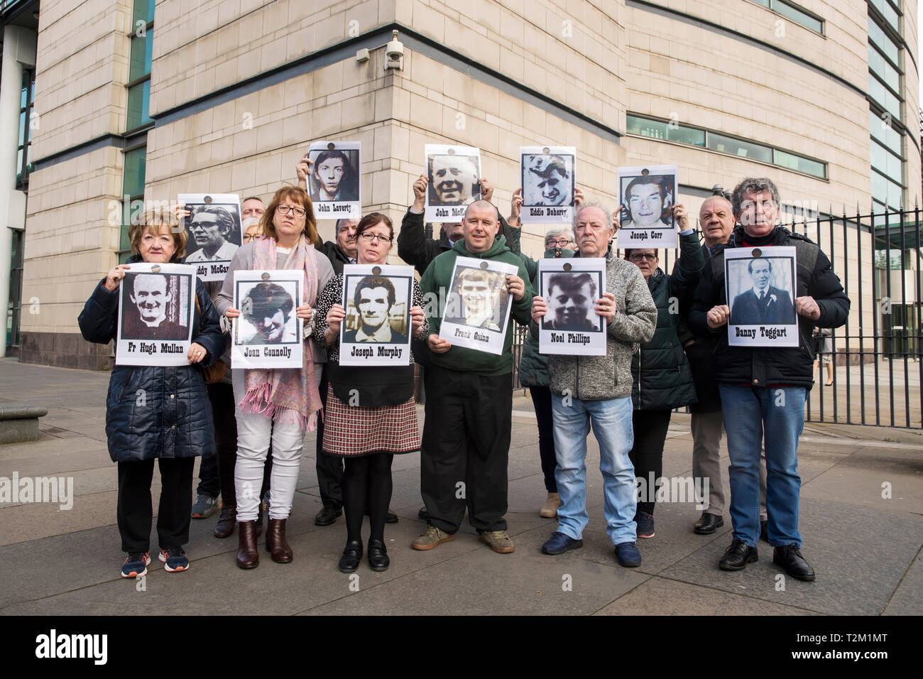 Le famiglie di coloro che sono stati uccisi durante la contestazione di un serie di tiri in Ballymurphy zona di Belfast nell' Agosto 1971 mantenere immagini dei loro cari con i sostenitori al di fuori di Belfast Laganside tribunali, Irlanda del Nord, durante una nuova inchiesta su i loro cari morti. Foto Stock