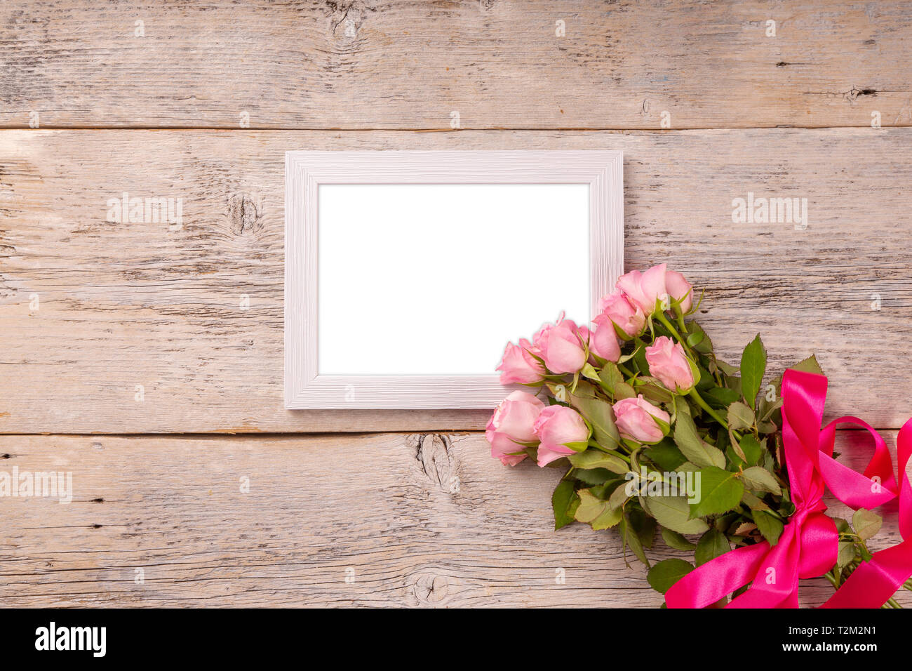 Il giorno di San Valentino o la festa della mamma biglietto di auguri e le rose su un tavolo di legno Foto Stock