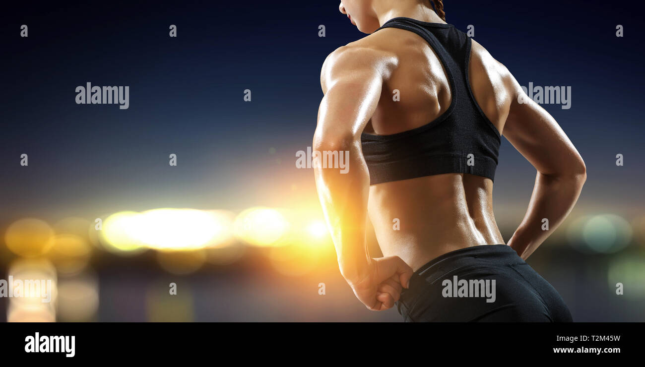 Lo sport femminile donna dimostrando i muscoli. I supporti misti Foto Stock