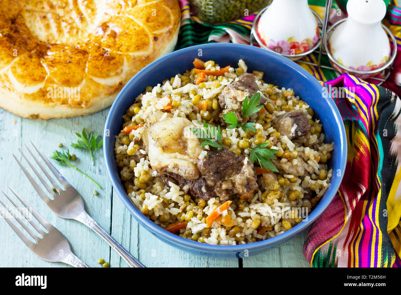 Cucina Araba. Eventi del Ramadan. Medio Oriente (Mashkichiri porridge realizzato di riso, carne di manzo e di Mung bean) su un tavolo di legno. Foto Stock