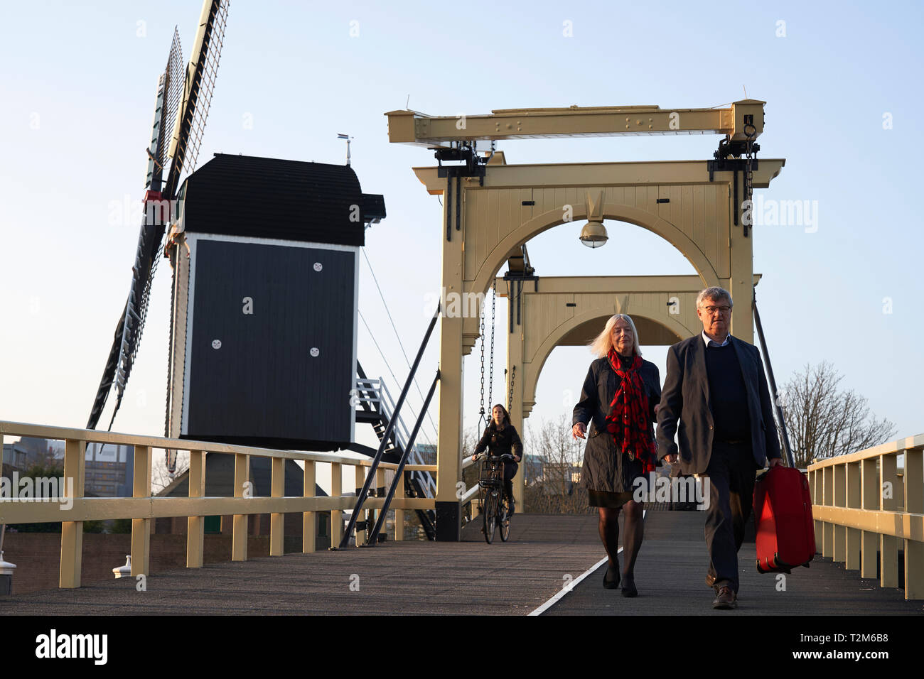 Parecchie persone attraversano il ponte di legno accanto alla De mettere mulino. Questo mulino risale al xvii secolo. Foto Stock