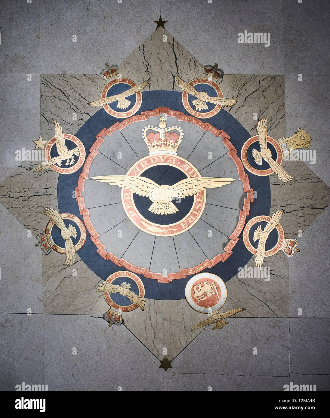 L'ottone e il pannello a mosaico sul pavimento di San Clemente Chiesa danesi, Londra, Regno Unito. La RAF cresta è circondato da creste di 8 Commonwealth Forze Aeree Foto Stock