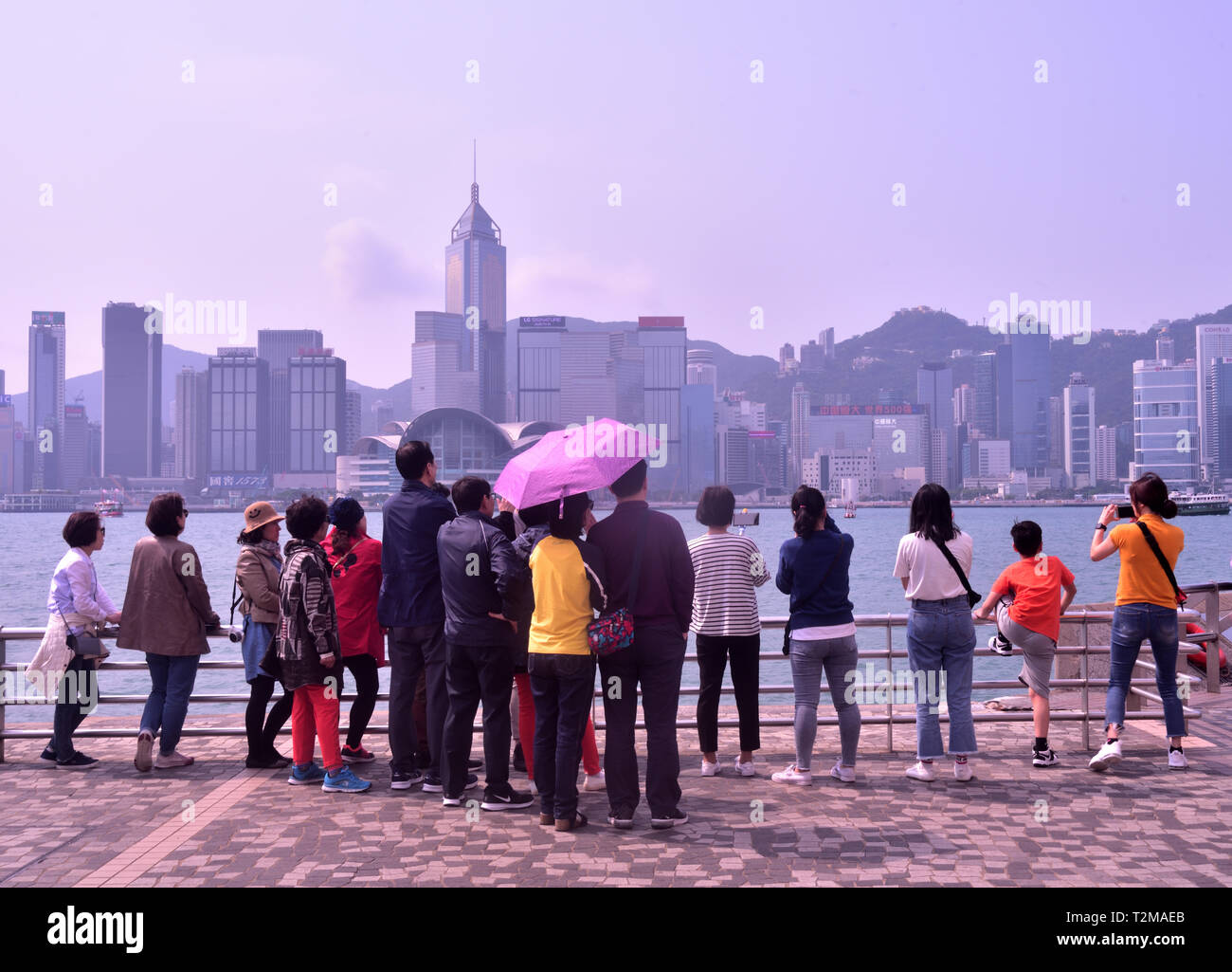 I visitatori si radunano in un punto panoramico in Tsim Sha Tsui Promenade, Hong Kong Foto Stock