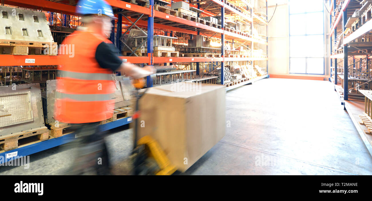 Logistica e trasporto dei lavoratori in un magazzino merci con merci per lo stoccaggio e la spedizione Foto Stock