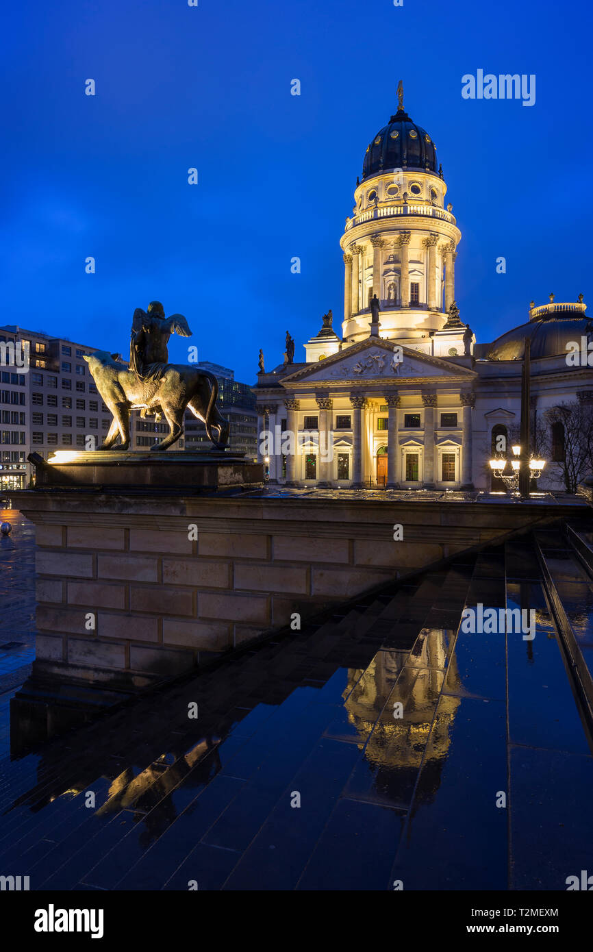 Accesa Neue Kirche (Deutscher Dom, la Chiesa tedesca o Cattedrale Tedesca) e una statua di fronte la Konzerthaus di Berlino presso la piazza Gendarmenmarkt al crepuscolo. Foto Stock