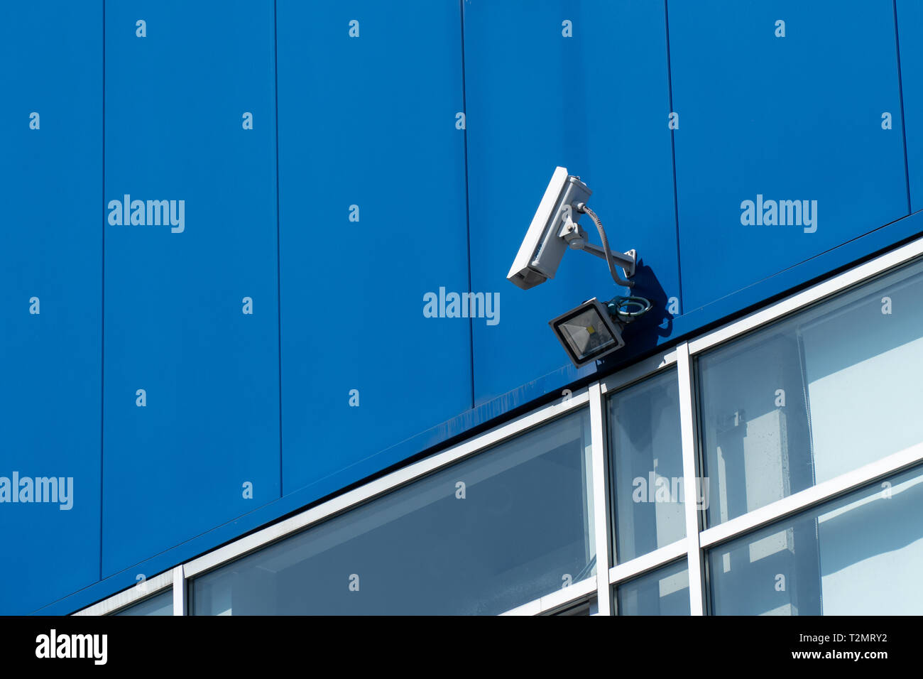 Concetto di sorveglianza. Videocamera di sicurezza su blu facciata di edificio Foto Stock