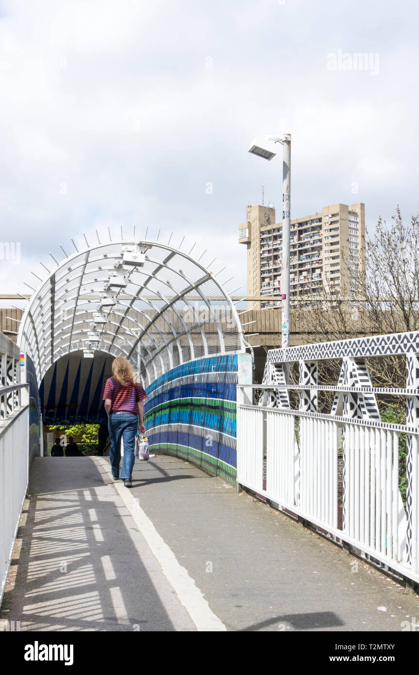 Una persona su una passerella su una linea ferroviaria e il sentiero sotto Westway, la A40, nella zona ovest di Londra. Foto Stock