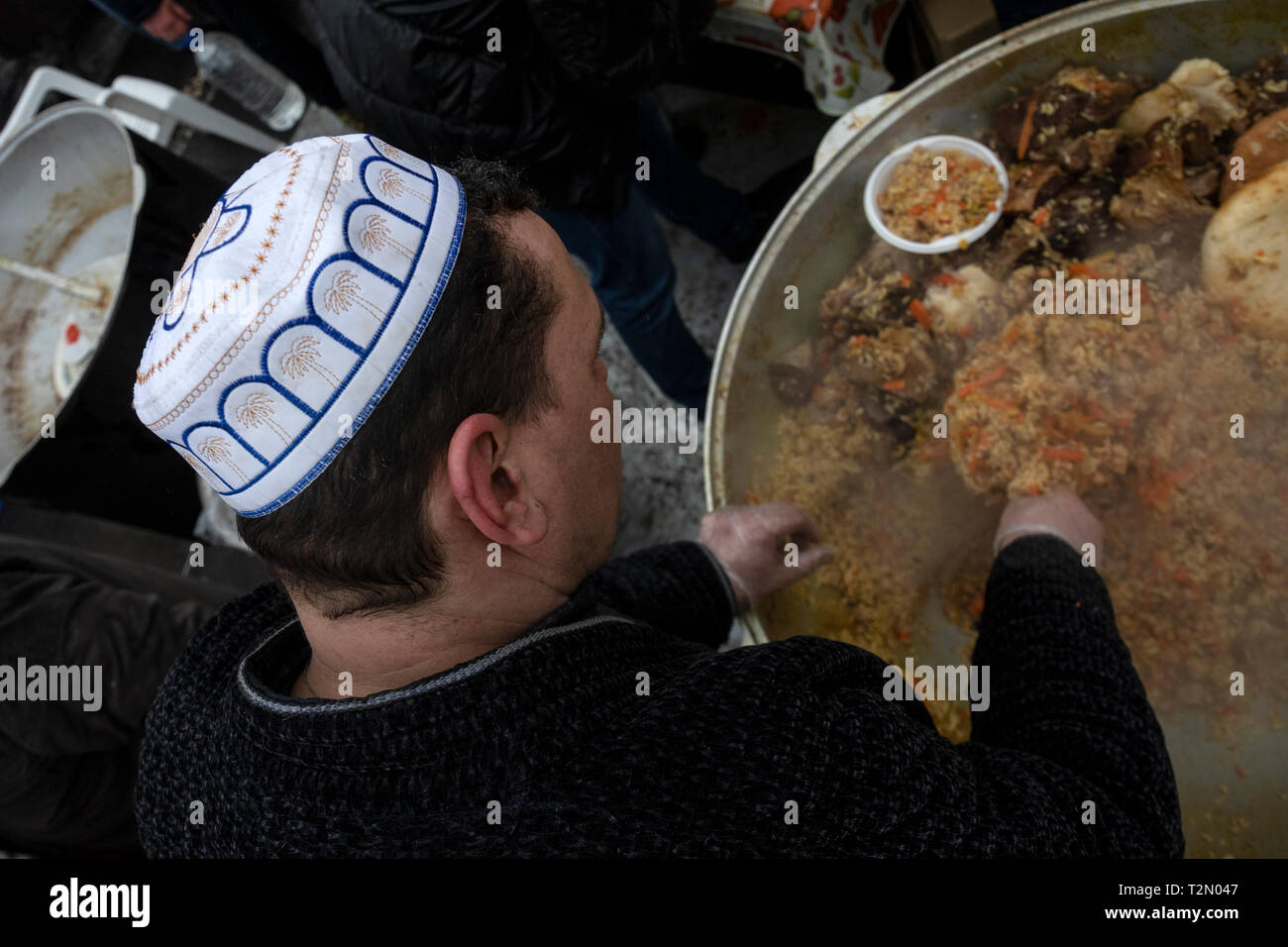 Cuocere in chapan e zucchetto preparazione pilaf in un paiolo di rame su strada Foto Stock