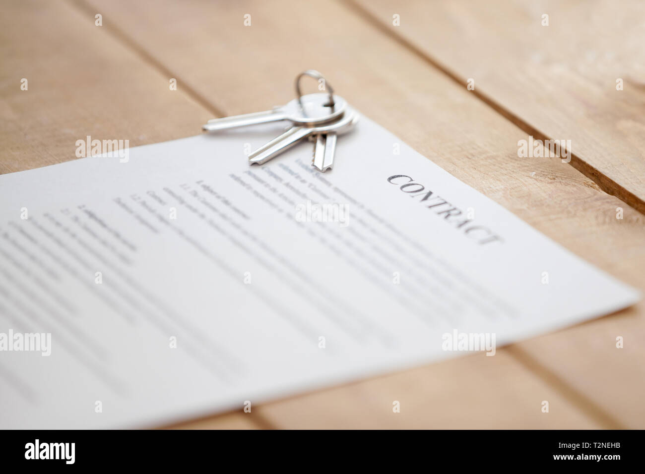 Close up di tasti giacente su un documento contrattuale carta su un tavolo di legno. Nuova abitazione o home riuscita operazione immobiliare, acquistare vendita, locazione e t Foto Stock