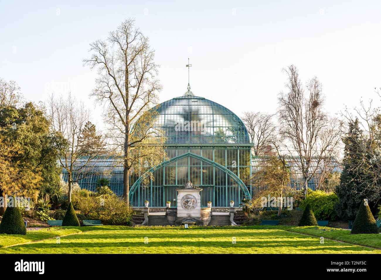 Vista frontale del palmarium, la grande serra delle palme nel Jardin des serres d'Auteuil a Parigi, Francia, alla fine di un assolato pomeriggio di primavera. Foto Stock