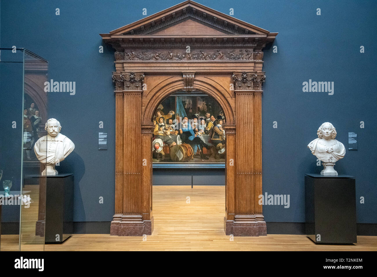 Un dipinto è incorniciato da un ornato arco in legno e due statue bianche nel Rijksmuseum di Amsterdam, Paesi Bassi Foto Stock