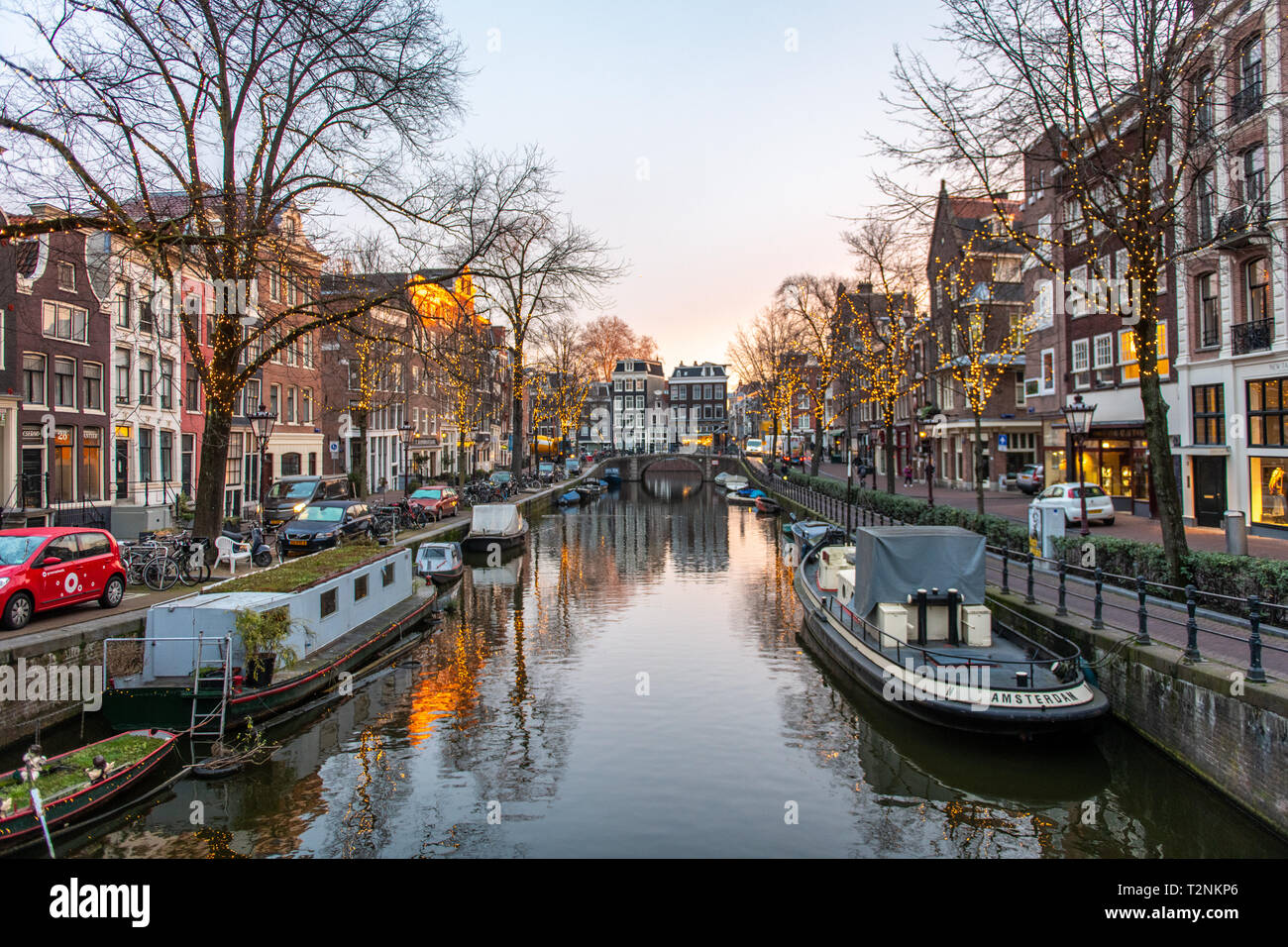 Una barca a leggere 'Amsterdam' è ancorata a un canale con molte altre barche in Amsterdam, Paesi Bassi Foto Stock