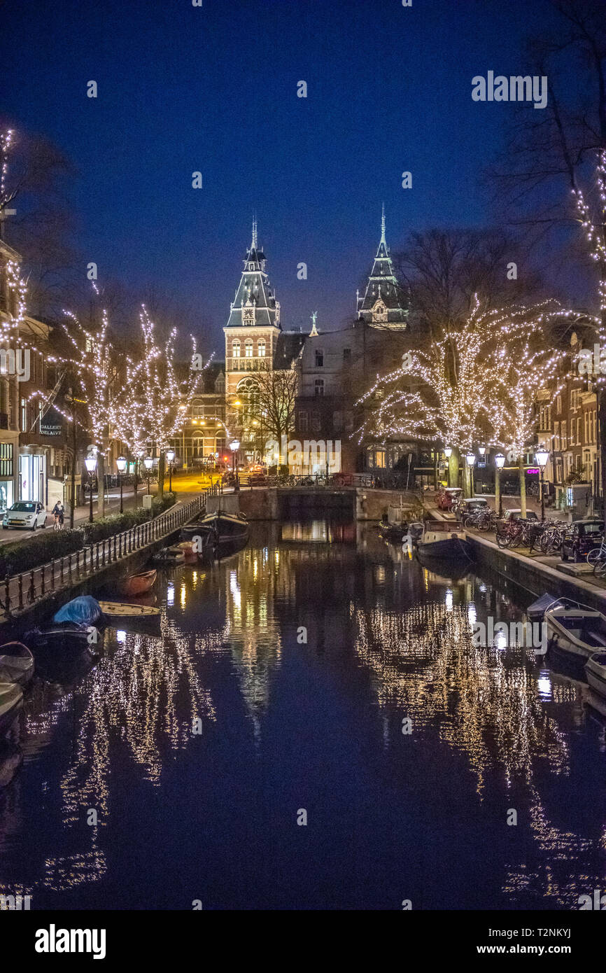 Bellissimi alberi luminosi la linea Amsterdam canal soprannominato "Venezia del Nord" che conduce al Rijksmuseum una storia olandese museum di Amsterdam, Net Foto Stock