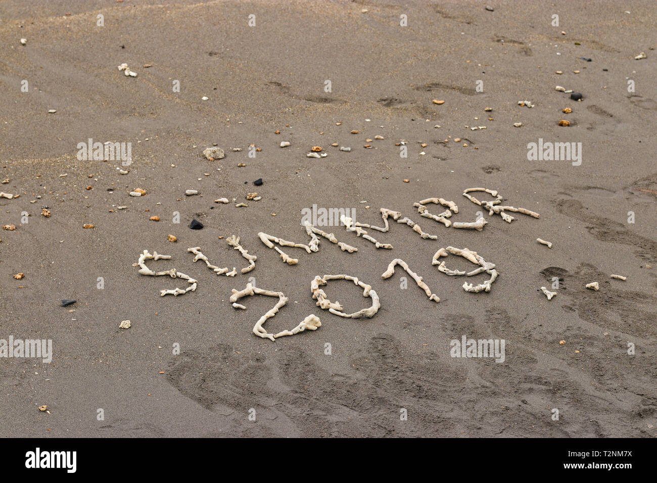 La scritta sulla sabbia di cui fuori di coralli, estate 2019 concetto di viaggio, con copia spazio per il testo Foto Stock