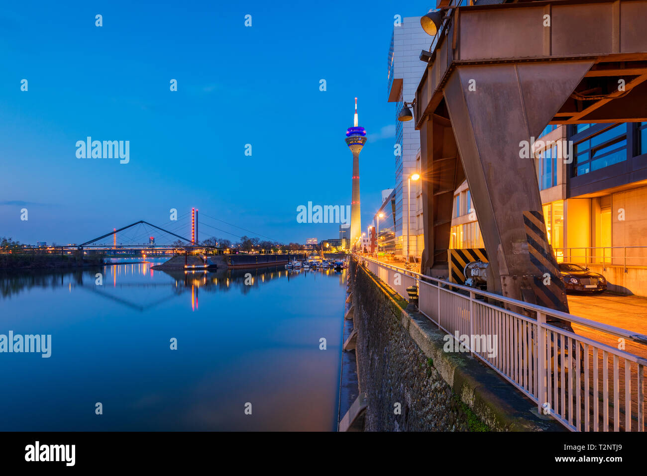 Porto di Düsseldorf in Germania con la famosa torre Rheinturm al crepuscolo Foto Stock