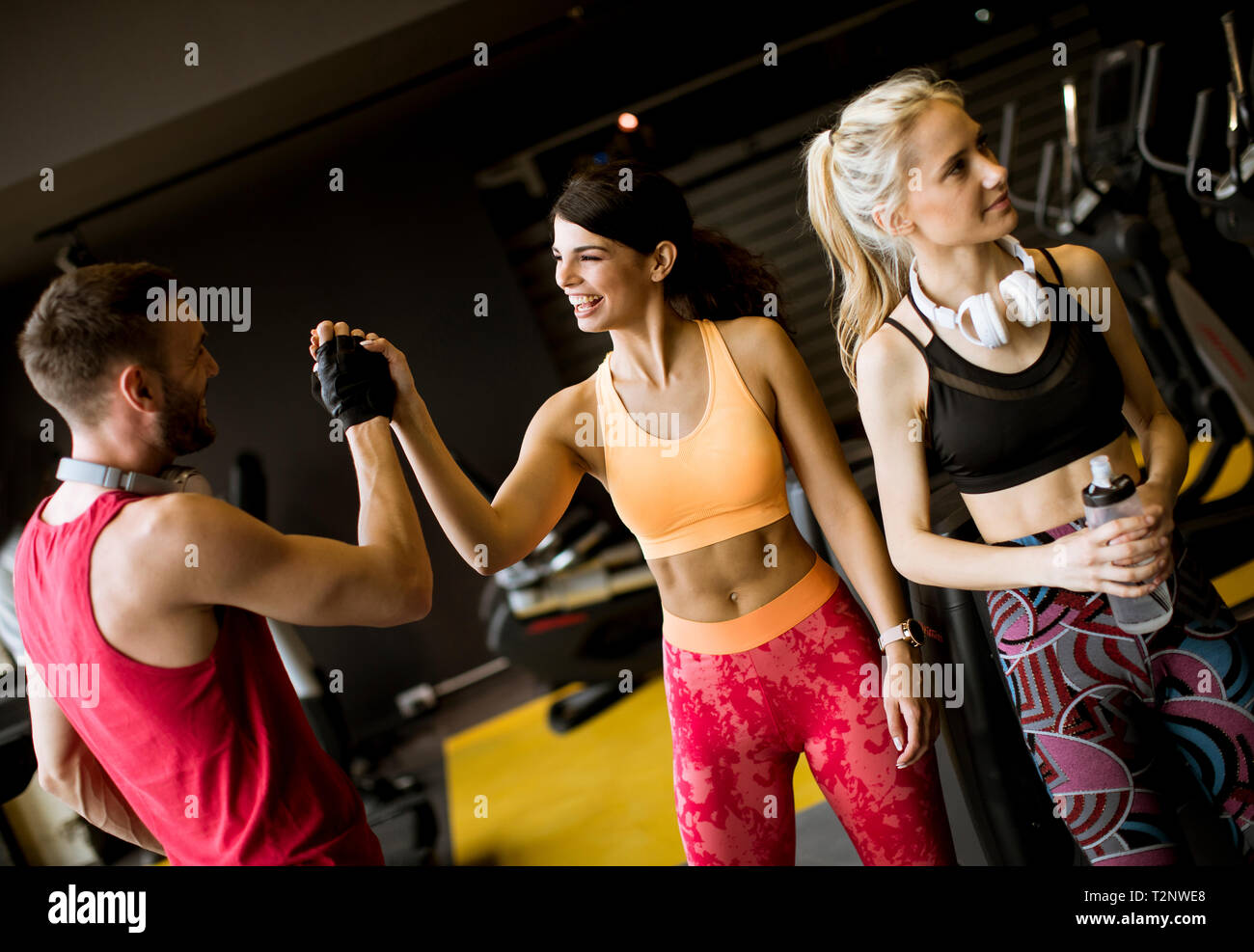 Giovane donna e personal trainer maschio resto in palestra dopo allenamento Foto Stock