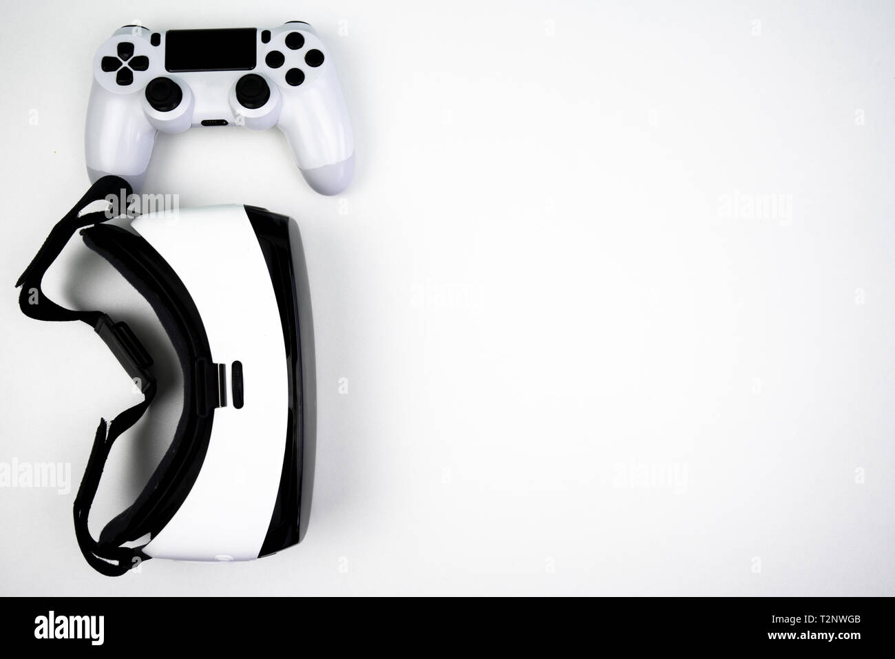 Vista dall'alto di una realtà virtuale auricolare con un controller di gioco su uno sfondo bianco. Divertirsi giocando con esso Foto Stock