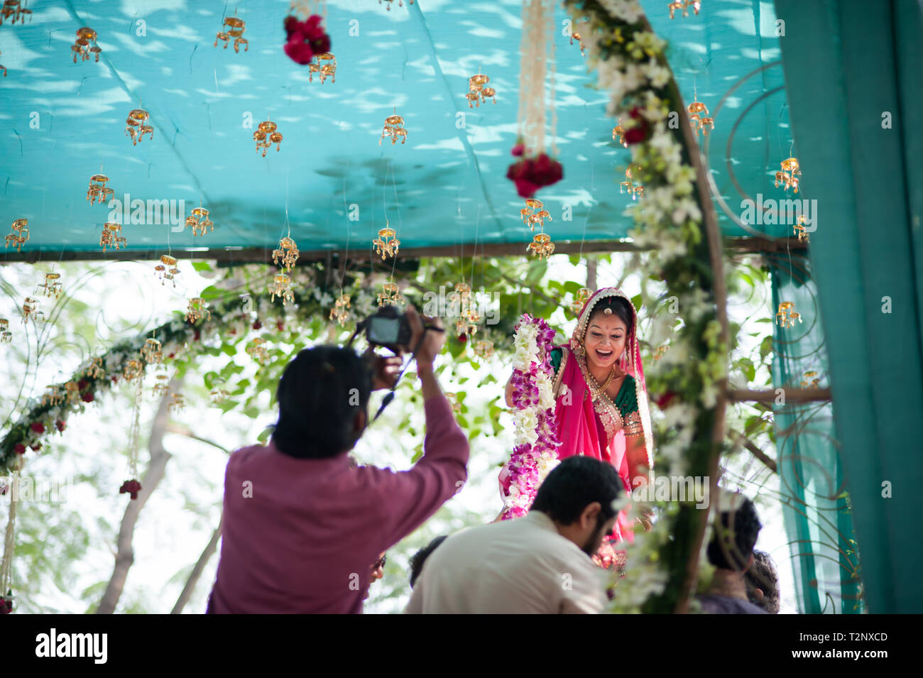 La felice sposa a un matrimonio indiano viene sollevato fuori i suoi piedi. Foto Stock